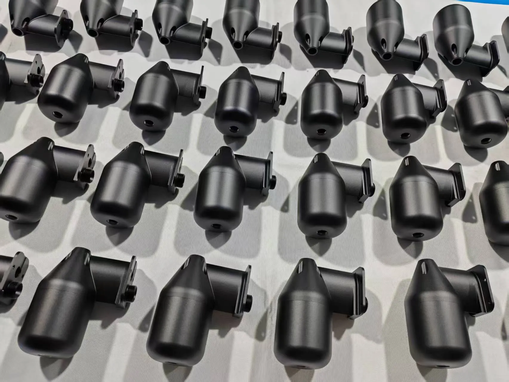 Batch of black curved CNC component assemblies with closely matched mating seams