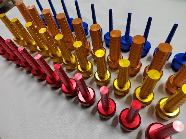 Multicolor anodized CNC parts in red, gold, and blue using advanced surface finishing technologies