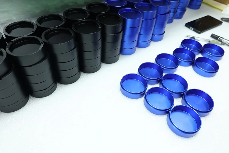 CNC machined aluminum snuff cans in blue and black colors, showcasing precision metal packaging design.