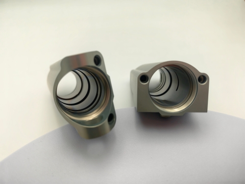 CNC machined grease manifold block with threaded ports and internal lubrication channels