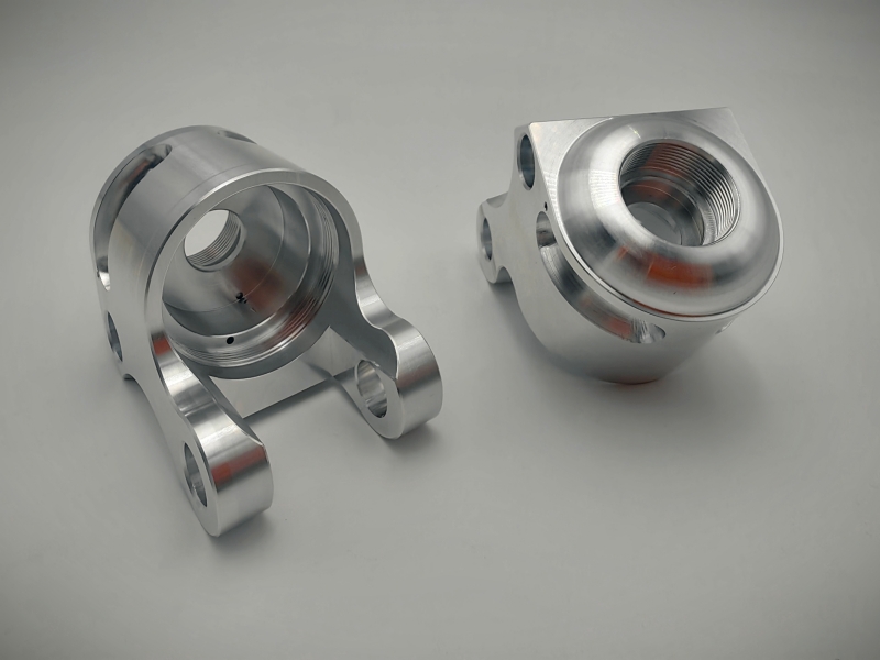 Precision CNC machined aluminum automotive joint housing with deep-thread bore and multi-axis milled yoke structure.

