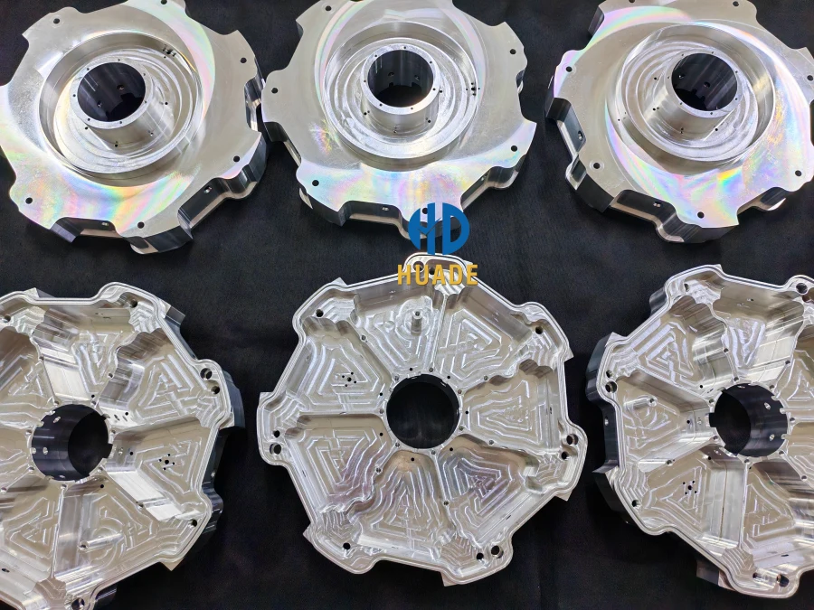High-complexity CNC machined aluminum housings with deep pockets, fine features, and multi-axis contours arranged on a dark background.

