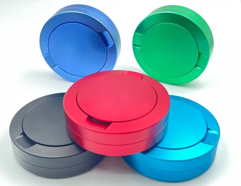 Various CNC machined metal snus cans in different colors and finishes